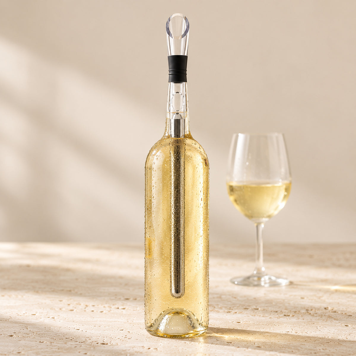 Enfriador de vino dentro de una botella de vino blanco con una copa servida